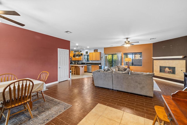 living room with ceiling fan and a fireplace