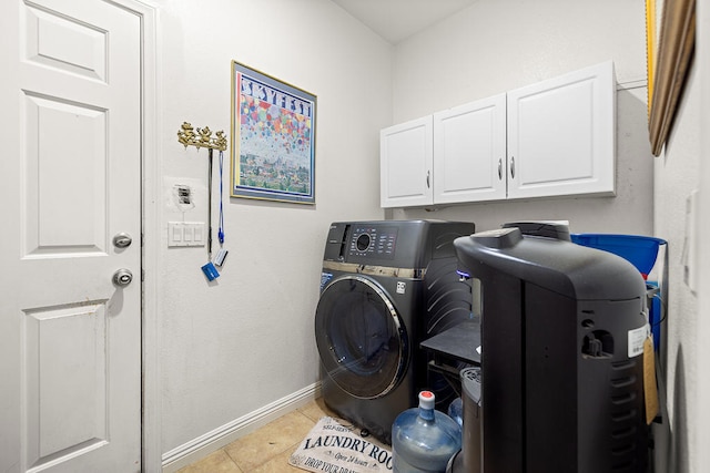 clothes washing area with washer / dryer, cabinets, and light tile patterned floors