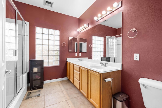 bathroom featuring toilet, vanity, an enclosed shower, and tile patterned floors