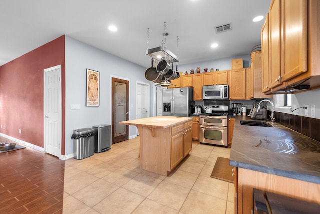 kitchen featuring appliances with stainless steel finishes, a kitchen island, and sink