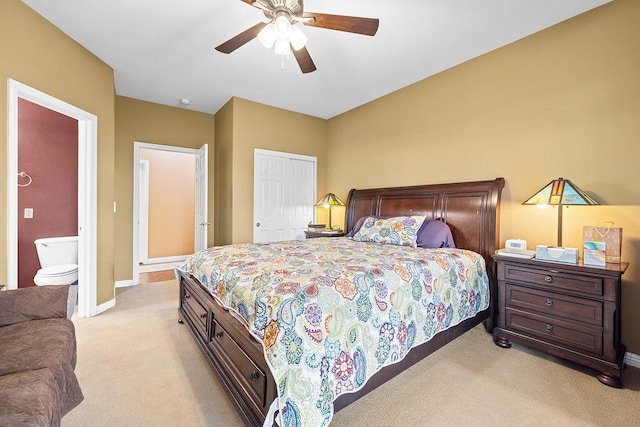 bedroom featuring ceiling fan, light carpet, and ensuite bathroom