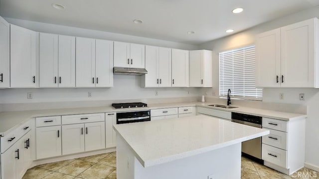 kitchen with white cabinets, sink, stainless steel appliances, and a center island