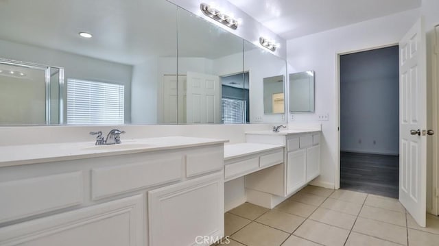 bathroom featuring walk in shower, vanity, and tile patterned flooring