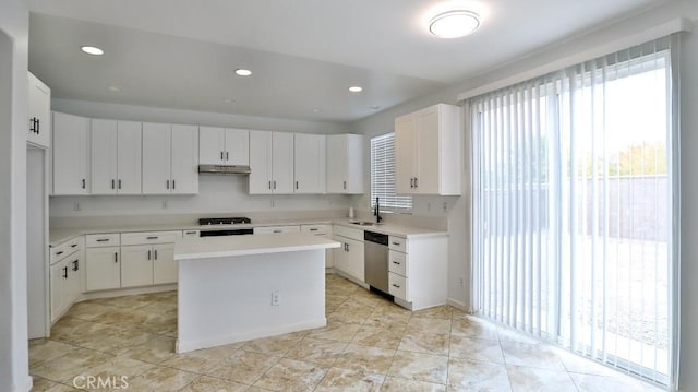 kitchen featuring stainless steel dishwasher, white cabinets, sink, and a center island