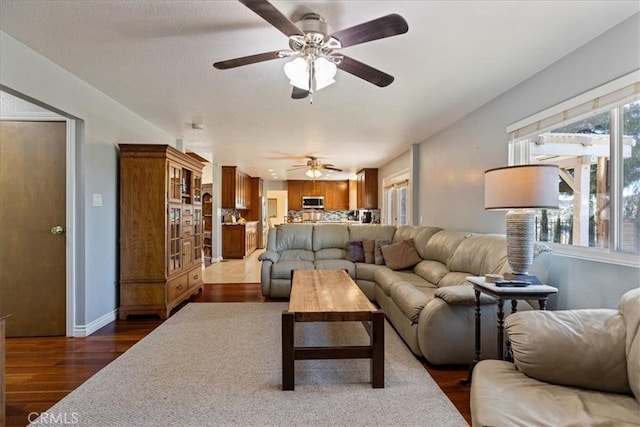 living room with ceiling fan and dark hardwood / wood-style flooring