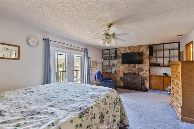 bedroom with a textured ceiling, ceiling fan, carpet flooring, and french doors