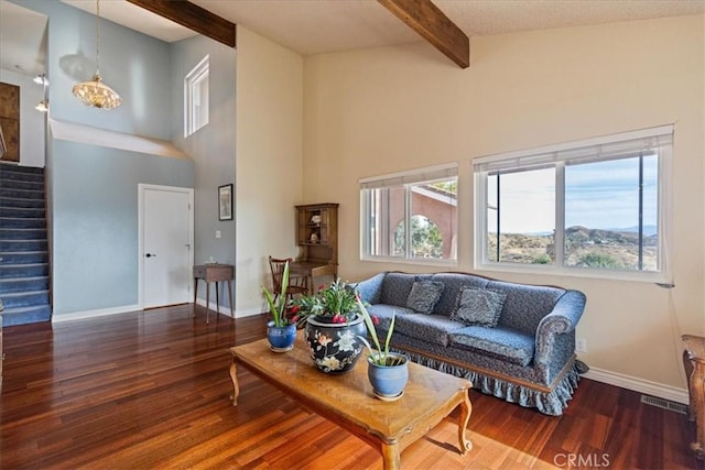 living room featuring dark wood-type flooring and beamed ceiling