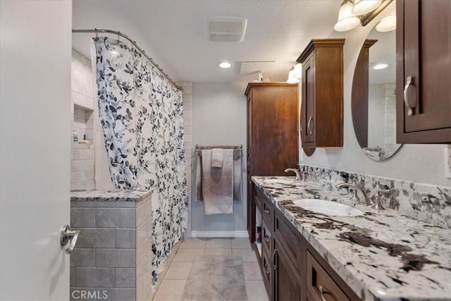 bathroom with a textured ceiling, tile patterned floors, and vanity