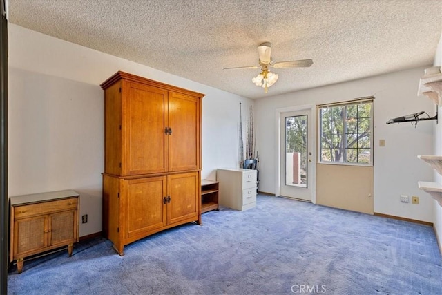 bedroom with ceiling fan, light colored carpet, access to exterior, and a textured ceiling