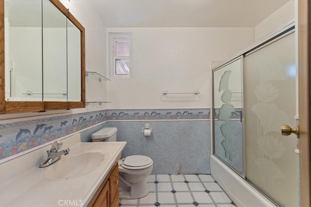 full bathroom with toilet, bath / shower combo with glass door, and vanity