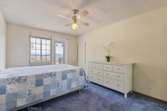 carpeted bedroom featuring a textured ceiling and ceiling fan