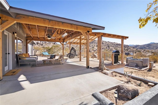 view of patio / terrace featuring a mountain view, a hot tub, and ceiling fan