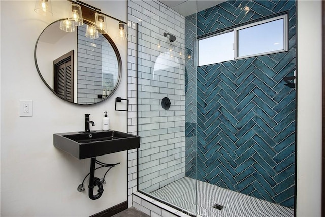 bathroom with a tile shower and sink