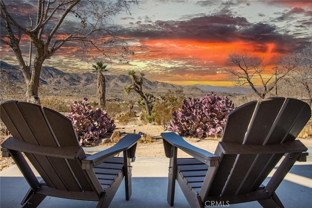 patio terrace at dusk featuring a mountain view