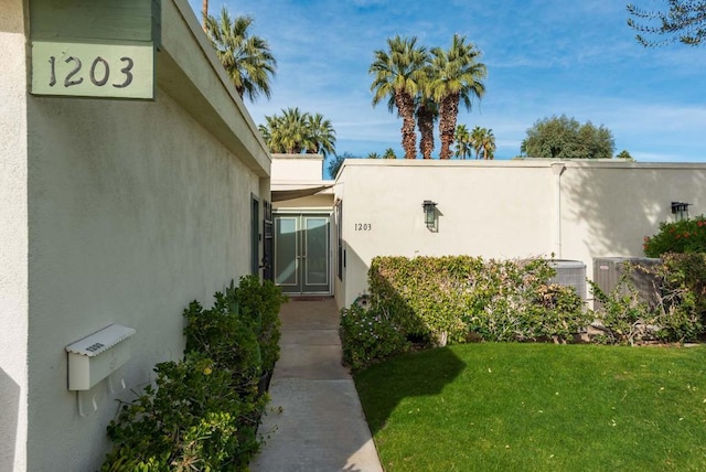 view of side of home featuring a lawn and central air condition unit