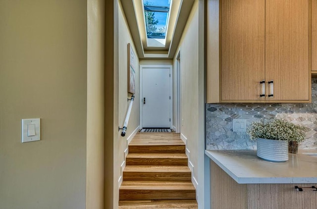 stairs with a skylight and wood-type flooring