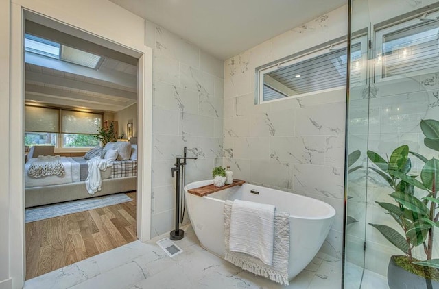 bathroom with tile walls, a bathtub, and wood-type flooring