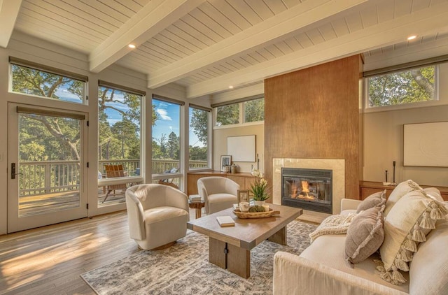 sunroom / solarium with a fireplace, wood ceiling, and beam ceiling