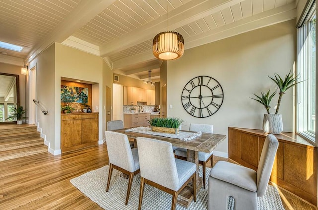 dining area with wooden ceiling, beam ceiling, and light hardwood / wood-style flooring