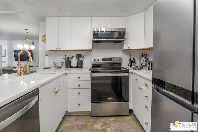 kitchen with sink, decorative light fixtures, white cabinets, and appliances with stainless steel finishes