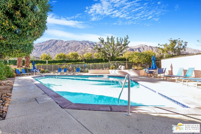 view of swimming pool with a mountain view and a patio