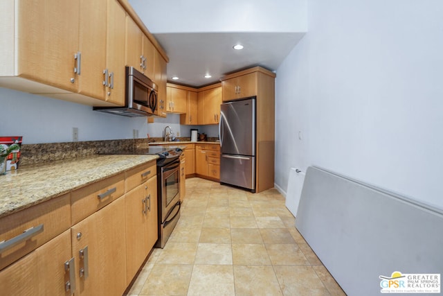 kitchen with stainless steel appliances, light tile patterned flooring, sink, and light stone counters