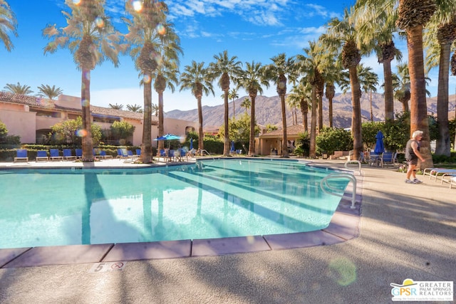 view of swimming pool featuring a patio and a mountain view