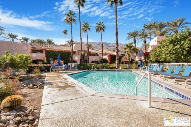 view of pool with a mountain view, a fireplace, and a patio area