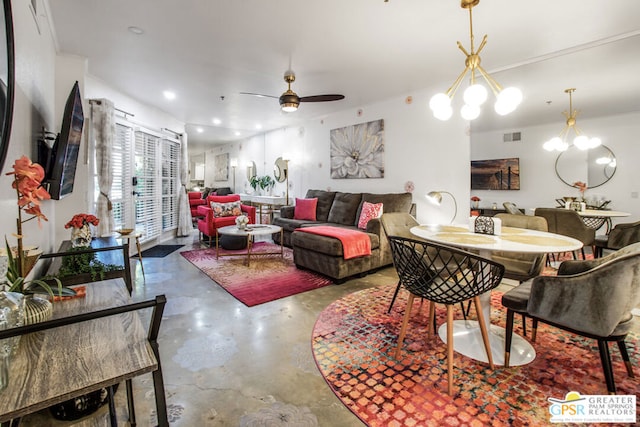 living room featuring ceiling fan with notable chandelier and concrete floors