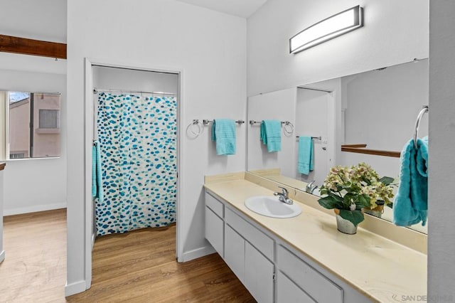 bathroom with hardwood / wood-style floors, vanity, and curtained shower