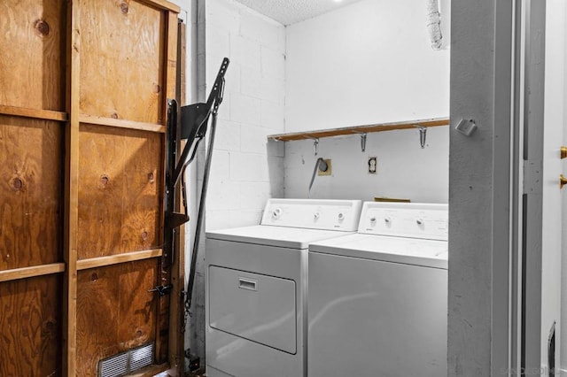 laundry room featuring separate washer and dryer and a textured ceiling