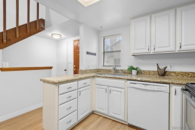 kitchen with kitchen peninsula, light wood-type flooring, dishwasher, white cabinets, and sink