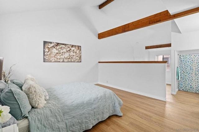 bedroom featuring light hardwood / wood-style floors, beam ceiling, and high vaulted ceiling