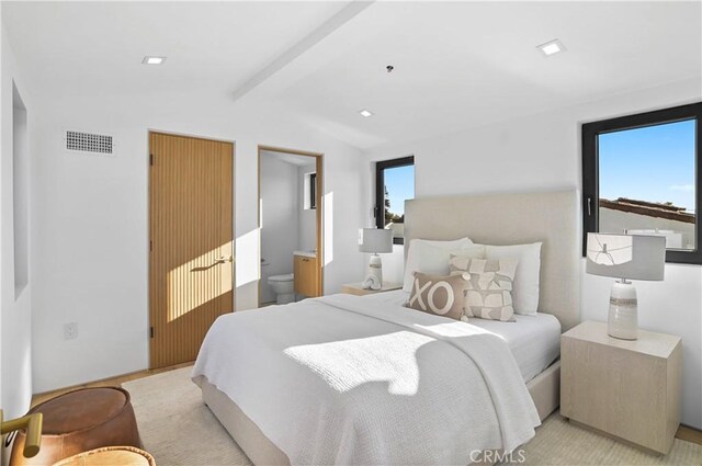 bedroom featuring multiple windows, ensuite bath, and lofted ceiling with beams