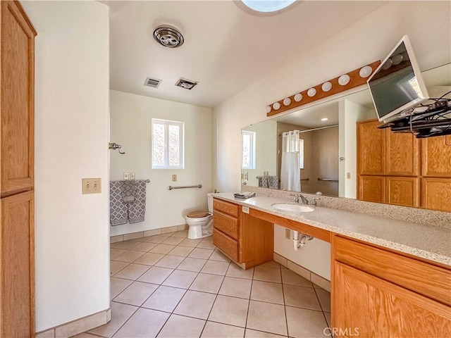 bathroom featuring toilet, tile patterned flooring, walk in shower, and vanity