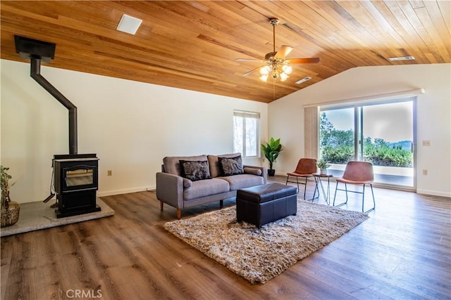 living room featuring ceiling fan, wood ceiling, a wood stove, and wood-type flooring