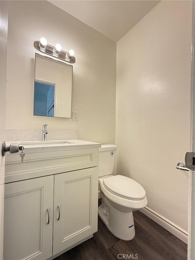 bathroom featuring hardwood / wood-style flooring, toilet, and vanity