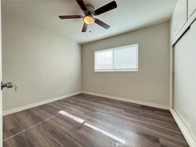 unfurnished bedroom with ceiling fan, dark wood-type flooring, and a closet