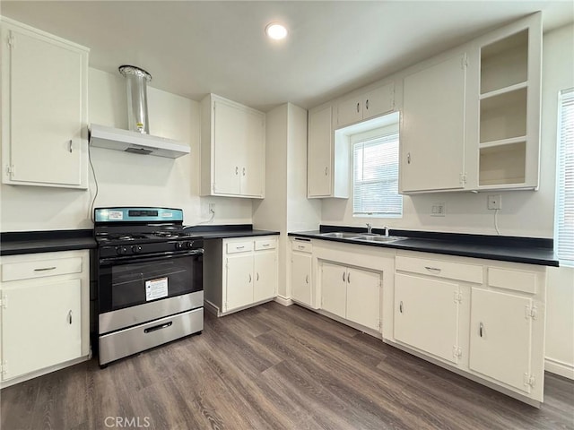 kitchen featuring wall chimney exhaust hood, range with gas stovetop, and white cabinetry