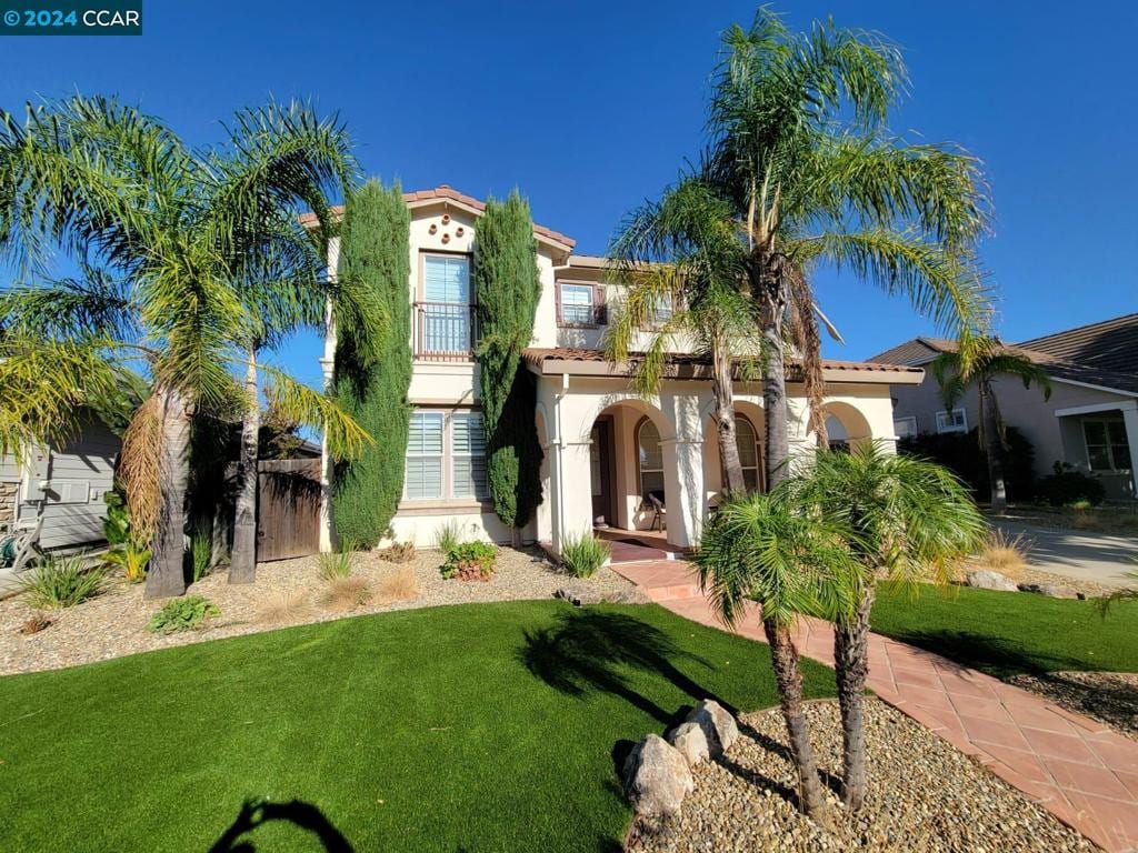 mediterranean / spanish-style house featuring a front yard