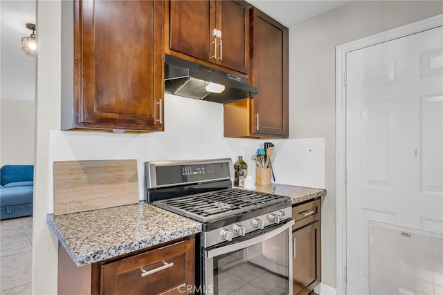 kitchen featuring light stone countertops, light tile patterned flooring, and gas stove