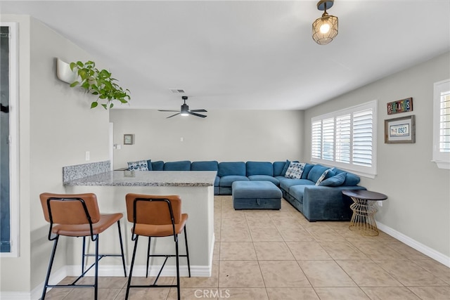 living room featuring ceiling fan and light tile patterned floors