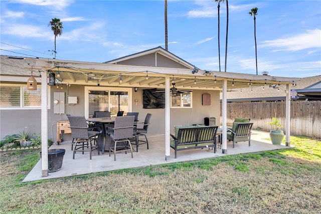 back of property with ceiling fan, a lawn, and a patio