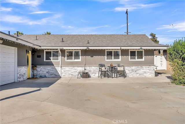 rear view of house featuring a garage and a patio area