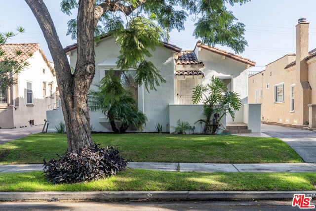 mediterranean / spanish home featuring a front lawn