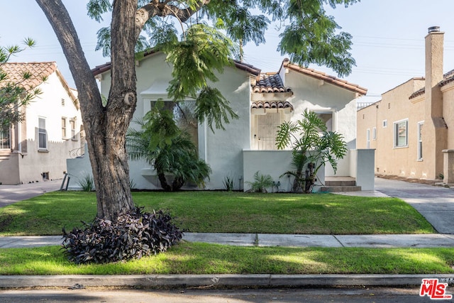 mediterranean / spanish home with a front lawn