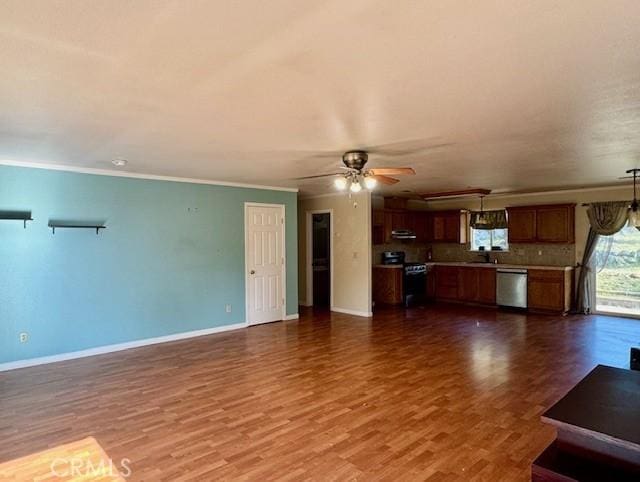 unfurnished living room featuring dark wood-type flooring, ceiling fan, ornamental molding, and sink