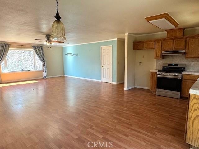 kitchen with ceiling fan, gas stove, tasteful backsplash, wood-type flooring, and pendant lighting