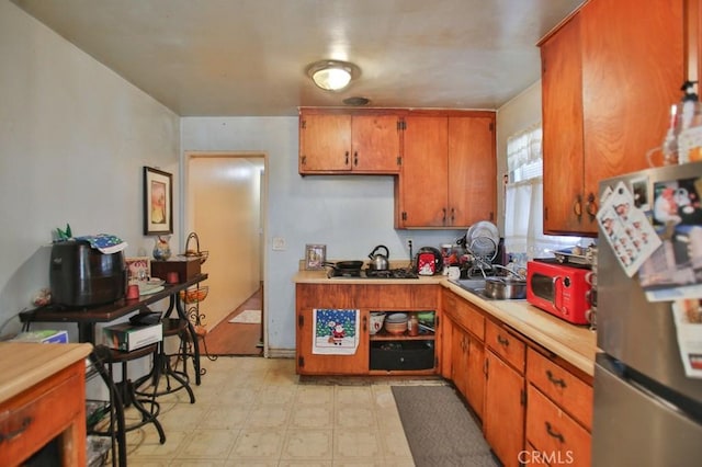 kitchen with stainless steel fridge, sink, and gas cooktop