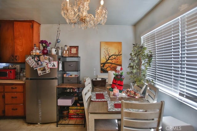 tiled dining room with a chandelier and a healthy amount of sunlight